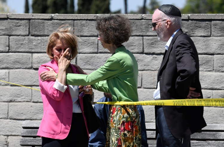 Synagogue members console one another outside of the Chabad of Poway Synagogue Saturday in Poway, Calif. Police have confirmed one is dead and three are injured. 
