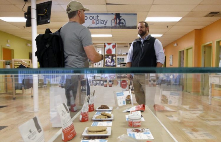 Scott Durst, left, a retired Maine DEA agent, discusses security concerns about selling marijuana with Ian Andrews, director of production operations at Wellness Connection in Portland. The state expects to have new rules by the end of 2019 to launch Maine's recreational, adult-use market. 