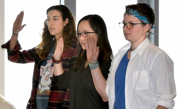 Colby College students, from left, Anna Braverman, Lutie Brown and Colleen George are sworn in to testify before the  Waterville Voter Registration Appeals board during a hearing in Waterville regarding voter eligibility on May 1.