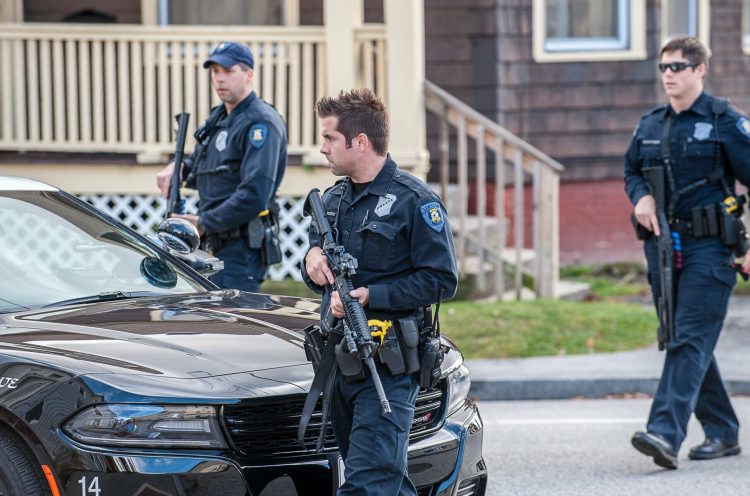 Officer Nicholas Meserve, center, and other Lewiston police officers search for a man who shot at a vehicle at the corner of Sabattus and College streets in 2016. Meserve's death in February has raised questions about whether municipalities require drug tests of employees.  