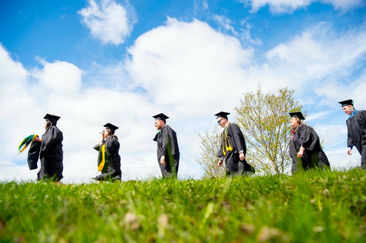 Unity College graduates approach Tozier Gymnasium on Saturday in Unity.