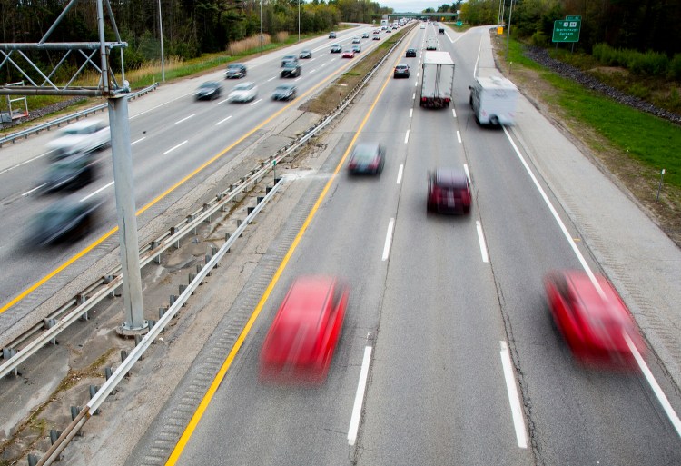 Steady traffic flows under the overpass near Exit 42 of the Maine Turnpike in Scarborough on Friday. The turnpike authority is projecting another record-breaking weekend for traffic.