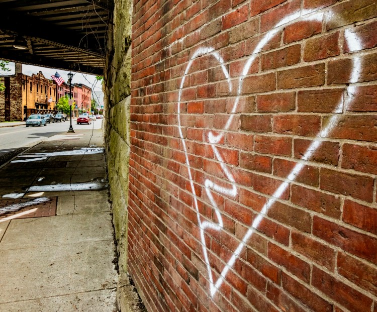 Graffiti painted on the front of the building at 98 Water St. is seen Thursday in Augusta.