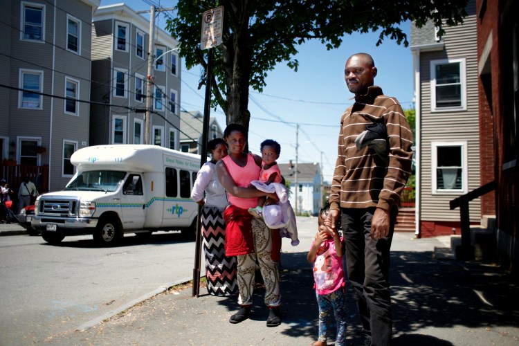 Mbemba Rey stands with family members on Chestnut Street outside the City of Portland Family Shelter on Wednesday. Rey, who does not speak English, was hesitant to share his story with a French-speaking reporter, but said he is originally from the Democratic Republic of Congo, and traveled through Central America to reach the United States. Rey said he arrived in Portland on Tuesday. 