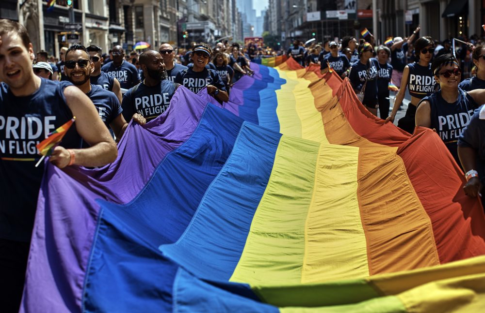 FILE- In this June 24, 2018 file photo, revelers carry a Rainbow Flag along Fifth Avenue during the New York City Pride Parade in New York. June 28, 2019 marks the 50th anniversary of the Stonewall uprising, which fueled the fire for a global LGBTQ movement. From symposiums to movie screenings, walking tours to art exhibits, even an opera, a slew of institutions and organizations are filling June with events that commemorate that moment and its impact through the last five decades. (AP Photo/Andres Kudacki, File)