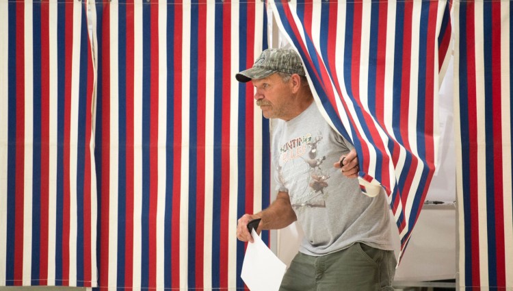 Jim Greene emerges from the voting booth Tuesday to cast his ballot on a new School Administrative District 49 budget at the Fairfield Town Office. 