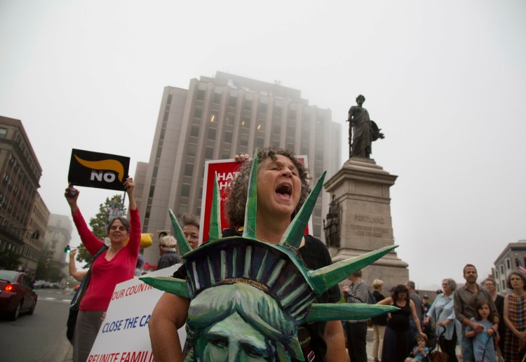 People protest the raids by ICE, expected to happen this weekend, at Monument Square on Friday evening. Naomi Mayer of Portland, from the group March Fourth, which organized after Trump took office, leads a group of protesters in a chant.
