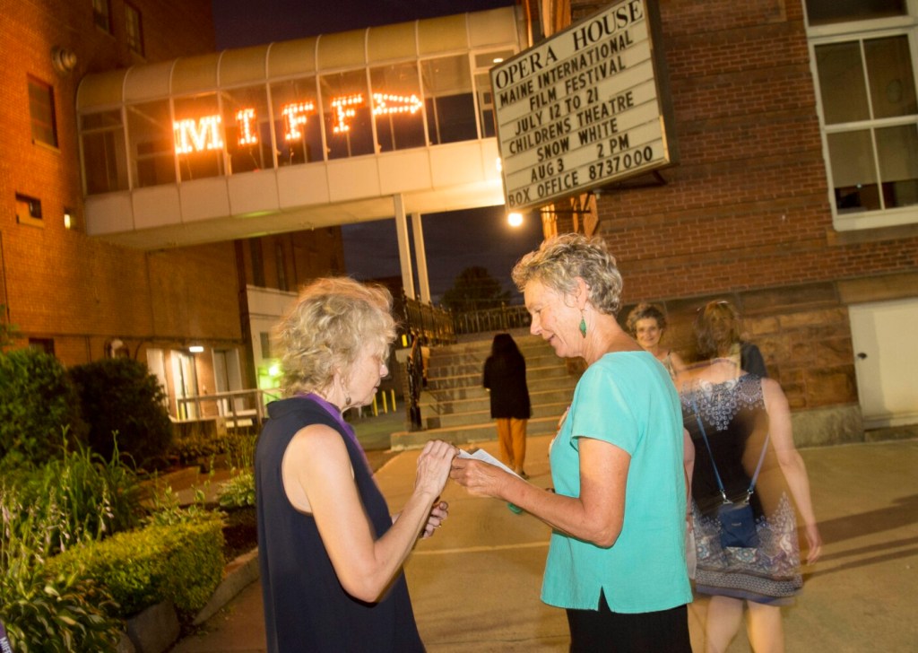 Former Waterville mayor Karen Heck speaks with a woman about the sexual assault shown in the 1970s film "The Last Tango in Paris" before it's showing Wednesday night at the Waterville Opera House during the Maine International Film Festival. 