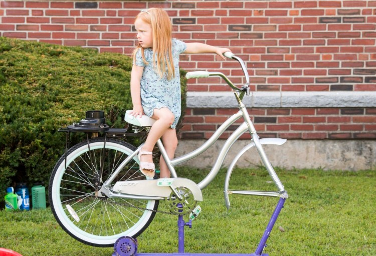 Norah Lockwood hangs out on a kid-powered, one-wheeled stationary bike that makes smoothies during Thursday's tour of the Children's Discovery Museum in Waterville.