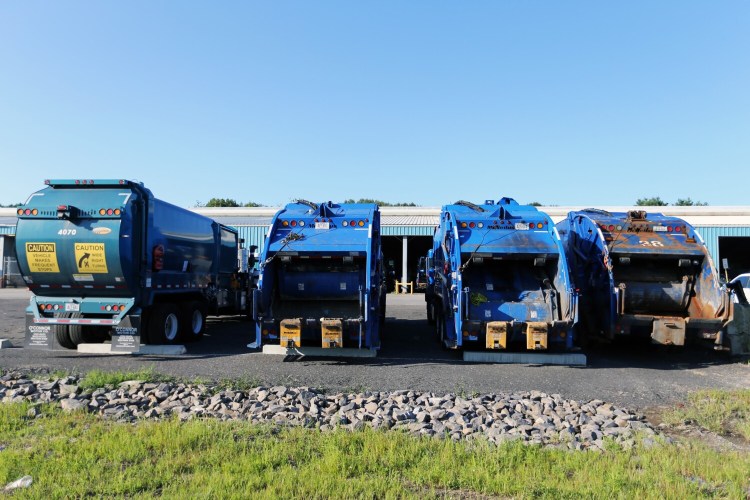 Dump trucks are parked outside Portland's city garage on District Road on Tuesday. City employee Martin Dinh, 46, was killed by his vehicle at the facility on Sunday.