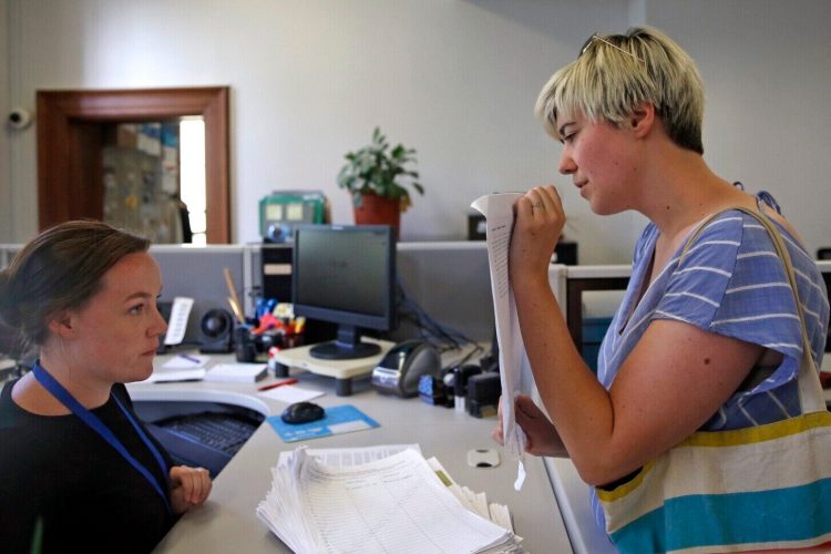 Anna Kellar, right, chair of the Fair Elections Steering Committee, delivers about 300 contested signatures to election assistant Jade Stevens at the City Clerk's office last year.