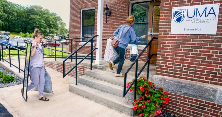 Claudia Lee, left, and Libby Bureau, both of Albion, carry things into Stevens Hall on Thursday, the new University of Maine at Augusta dormitory in Hallowell.