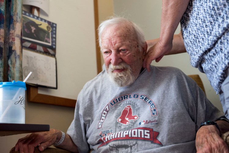Beth Lagasse, 55, looks over her father, James Lagasse, 84, after his first night at a nursing home in Dover-Foxcroft. James Lagasse had a stroke the previous week. 
