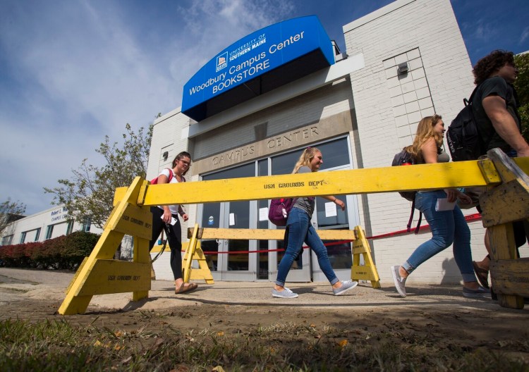 Students walk past Woodbury Campus Center, the hub of the University of Southern Maine’s Portland campus, which will be closed for at least two weeks while crews work to repair the damage caused by a fire main break. 