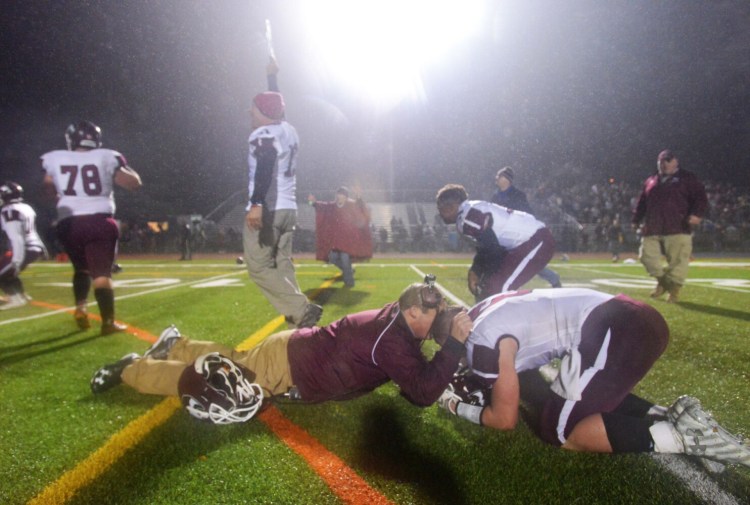 Maine Central Institute coach Tom Bertrand, left, celebrates with a player after the Huskies stunned Lisbon in the 2016 Class D state title game in Portland on a last-second touchdown.  last second touchdown to beat  Lisbon High School 20-14 for the Class D state championship title with Adam Bertrand (6) at Fitzpatrick Stadium in Portland on Saturday, Nov. 19, 2016.  ()