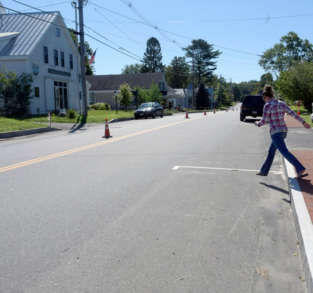 Amy Soper steps off the new curb Thursday in Belgrade.