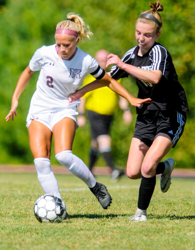 Monmouth Academy striker Audrey Fletcher, left, dribbles around Hall-Dale midfielder Rita Benoit during a game earlier this season in Farmingdale.