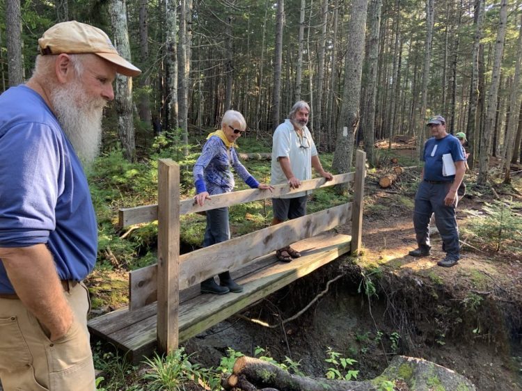 From left, recreation committee member Tom Carr, Selectman Jane Covey, Select Board Chairman Kevin Johnson and recreation committee member Tony Barrett tour the Cliff Trail, looking for hazards for those with limited mobility.