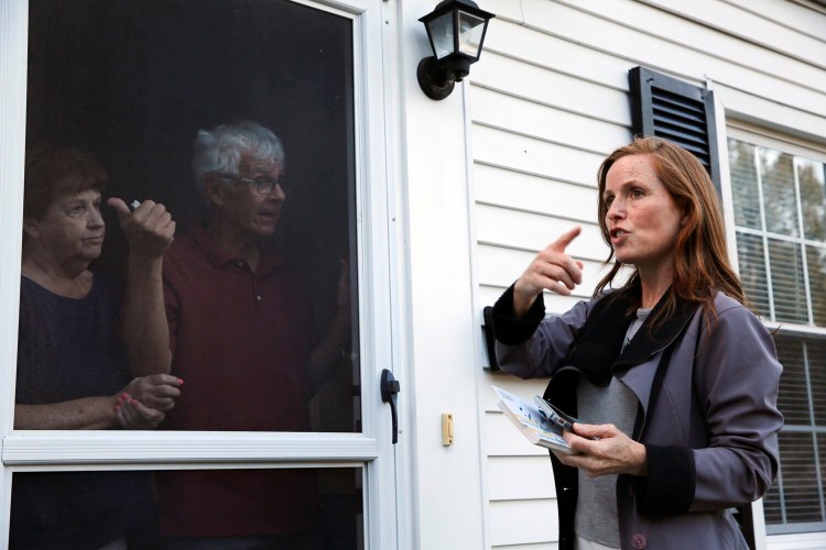 Portland mayoral candidate Kate Snyder talks about tight on-street parking with Libbytown residents Beverly and Dennis Moran while campaigning door-to-door last month.