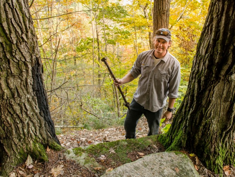 Jean-Luc Theriault, stewardship director for the Kennebec Land Trust, holds rusty bolts Tuesday that were found near a set of granite steps where the Gannettston House in the Trees used to be in the Howard Hill Historical Park in Augusta.