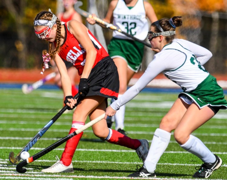Lily Clough, left, of Wells tries to pass past Winthrop's Abbie Ross during a Class C South semifinal game on Saturday, October.=