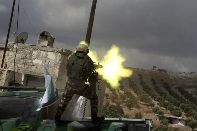 A fighter from Turkish-backed forces of the Free Syrian Army fires a heavy machine gun during military training maneuvers Monday near Azaz, Syria, in preparation for an anticipated Turkish incursion targeting Syrian Kurdish fighters. 