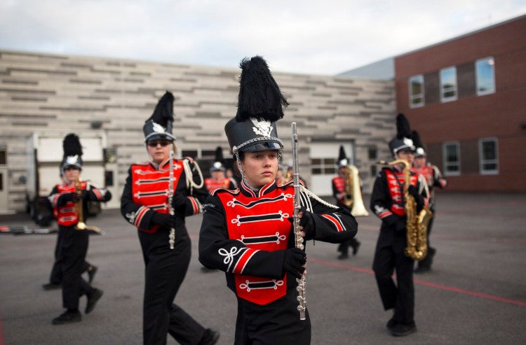 Less than an hour before state finals, eighth-grader and flute player Katie Dallaire practices steps with the band behind Sanford High. 