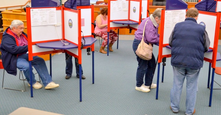 Voters sit and stand as they fill in their ballots on Nov. 5, 2019, at Augusta City Center.