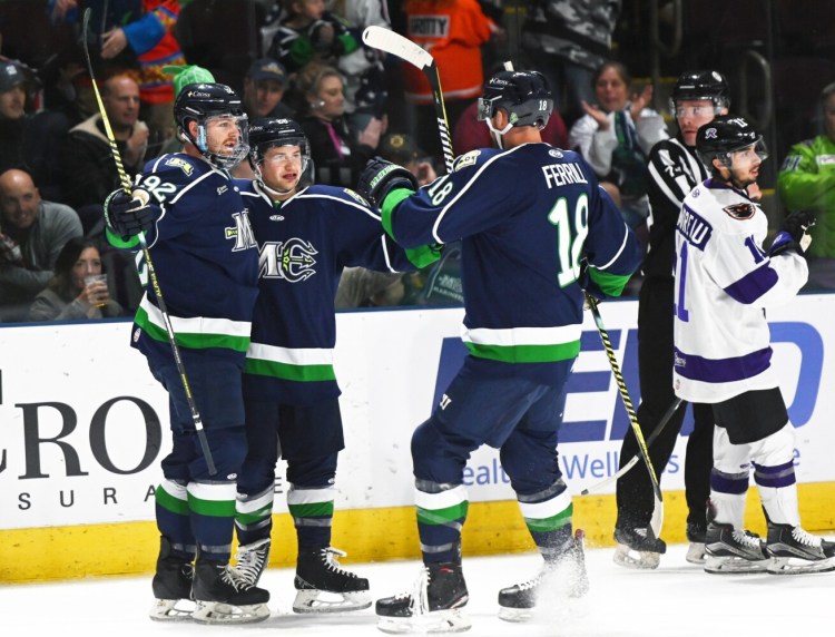 Maine's Terrence Wallin, Taylor Cammarata and Ryan Ferrill celebrate a first period goal during the Mariners' 4-3 win over Reading on Monday at Cross Insurance Arena.