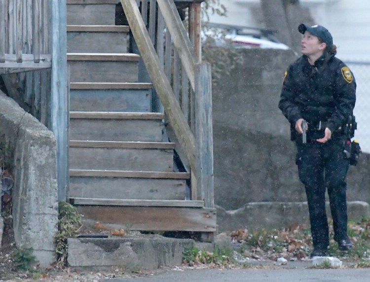 An Augusta police officer approaches 93 Northern Ave. on Monday after police received a report of gunfire at the building.