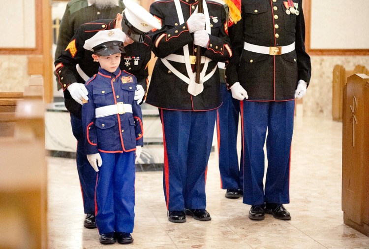 Parker Kelly, 6, of Lewiston gets last-second instructions from his great-grandfather, U.S. Marine Corps veteran Raymond Masse of Lewiston, during the 16th annual Veterans Day Community Prayer Service processional Monday at Holy Family Church in Lewiston. The five branches of the military were honored during the hourlong service. Masse, 82, said this is the third year Kelly has participated in the event with him.