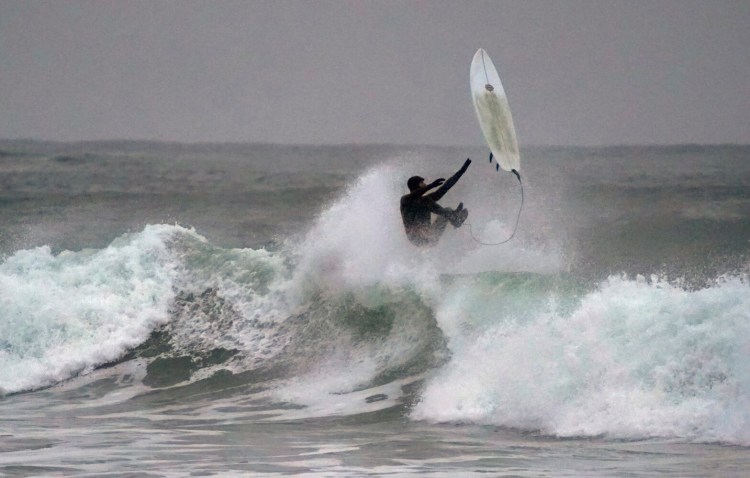 A surfer comes off his board while riding a wave at Gooch's Beach in Kennebunk on Monday. More than a dozen surfers took advantage of sizable swells off the beach during high tide. The waves were big enough to also breach the seawall and cause minor flooding along nearby Beach Avenue.