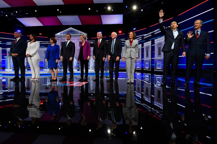 Democratic presidential candidates, from left, Cory Booker, Tulsi Gabbard, Amy Klobuchar, Pete Buttigieg, Elizabeth Warren, Joe Biden, Bernie Sanders, Kamala Harris, Andrew Yang and Tom Steyer wave to the audience before Wednesday's Democratic debate in Atlanta.