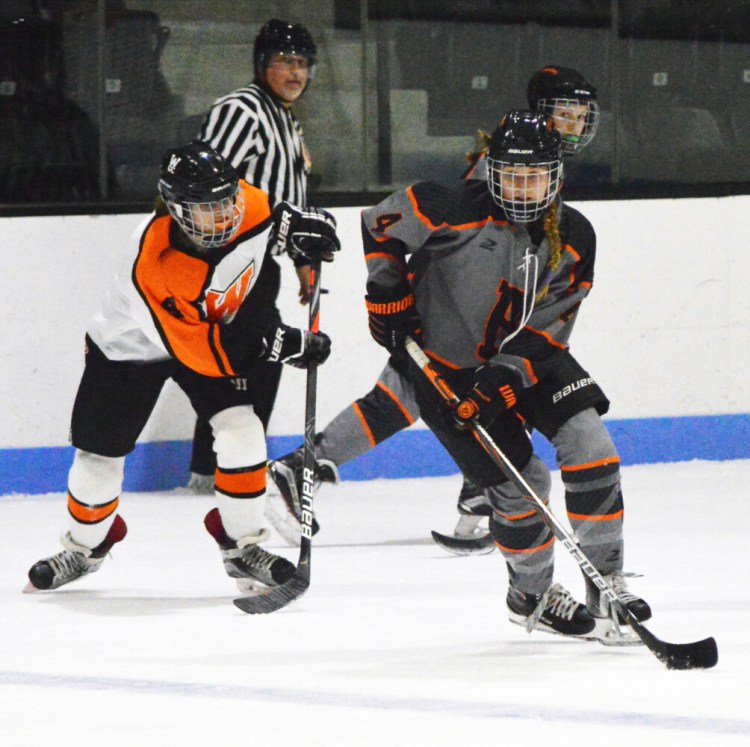 Brunswick's Greta White skates ahead of Winslow/Gardiner/Cony's Alayna Blier during the second period of a girls high school hockey game at Sidney J. Watson Arena at Bowdoin College in Brunswick earlier this season.