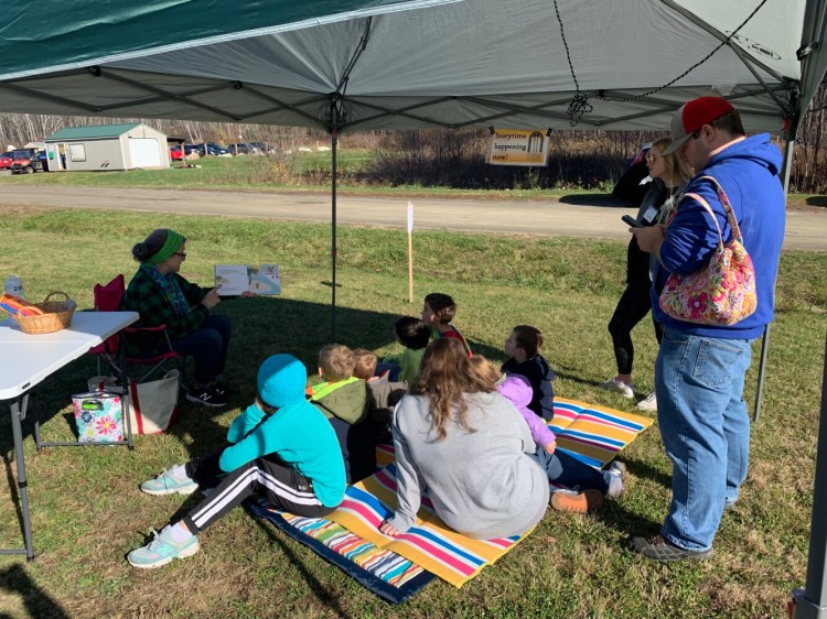 Liz Davis, Waterville Public Library's children's librarian reads "This Tree Counts" to young children Saturday during the Quarry Road Trails Fall Festival in Waterville.