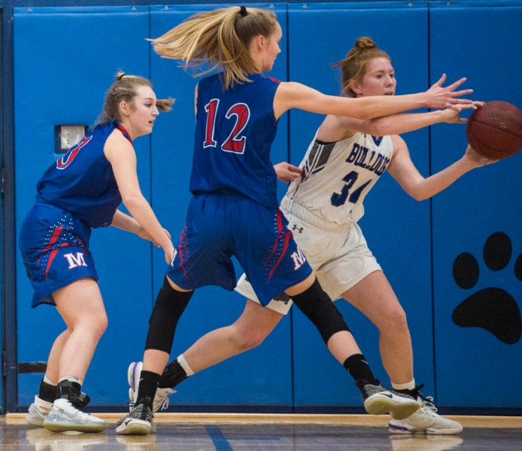 Lawrence's Sarah Poli (34) looks to pass the ball while being defended by Messalonskee's Grace Wener (12) and Brooke Martin, left, on Tuesday in Fairfield.