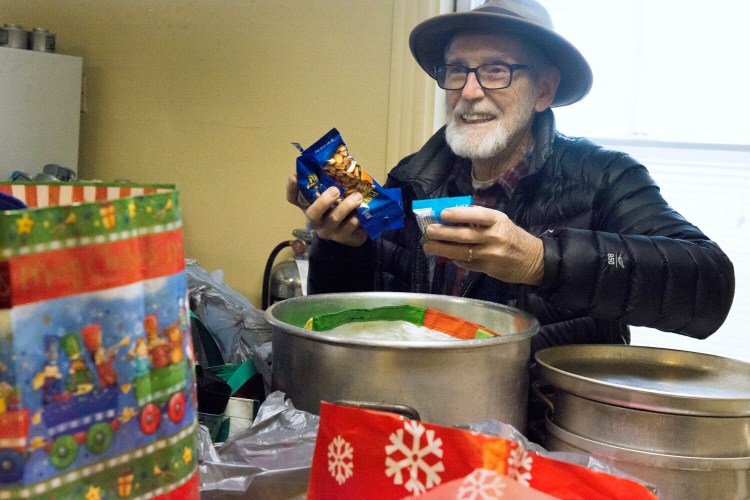 Peter Carleton, a volunteer at the church, looks through the contents of some of the gift bags donated to the warming center at St. Luke's Cathedral in Portland on Wednesday.  