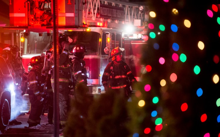 Firefighters stand outside 66 Oak St. in Waterville where a fire in the attic had been reported Thursday.