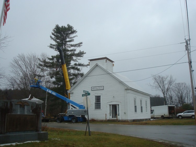 A temporary cap was placed on the base of the bell tower structure while a member of the crane and rigging crew descends in a powered man-lift.