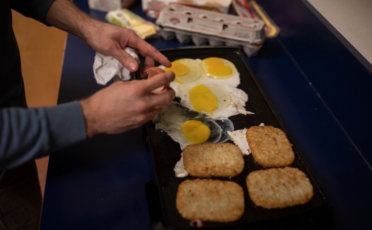 Deckhand Greg Jukins makes breakfast sandwiches for himself and a few of his co-workers in the Casco Bay Ferry Terminal break room on a recent Saturday.  Warm food is imperative on cold winter days spent working outside. 