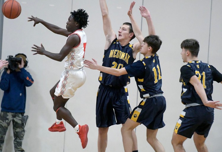 Cony's Simon McCormick passes through the Medomak Valley  defense Tuesday in Augusta. 