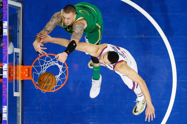 Boston's Daniel Theis, left, dunks against Philadelphia's Ben Simmons during Thursday's game in Philadelphia. 
