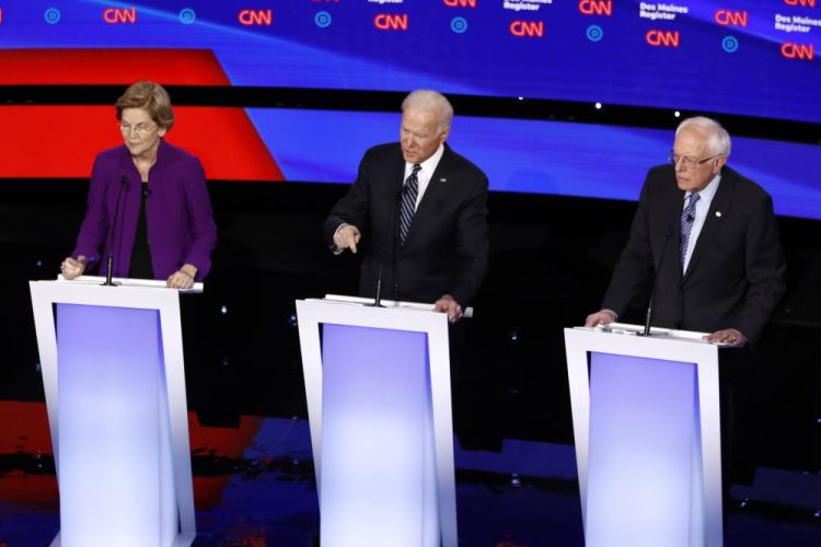 Democratic presidential candidates Sen. Elizabeth Warren, D-Mass., from left, former Vice President Joe Biden and Sen. Bernie Sanders, I-Vt., on stage, Tuesday, during a Democratic presidential primary debate in Des Moines, Iowa. 