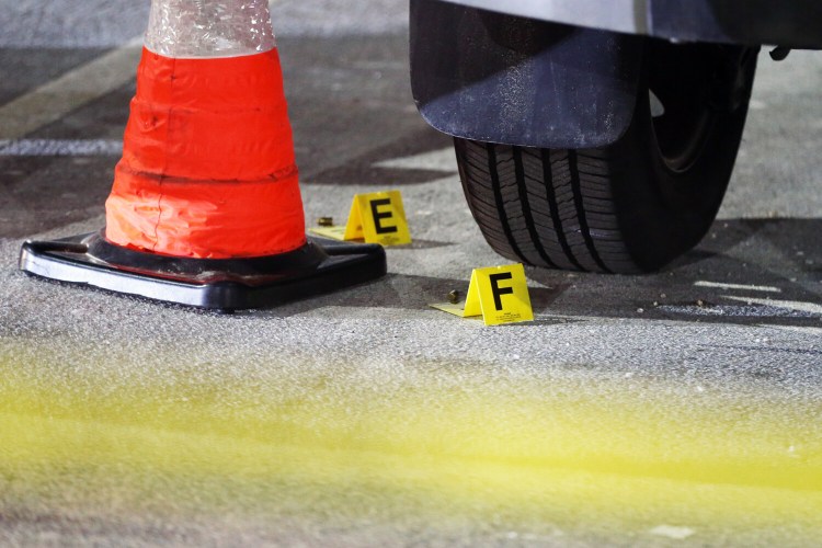 Evidence markers show the locations of shell casings behind the tire of a Toyota Tundra pickup truck at the scene of Friday's shooting.