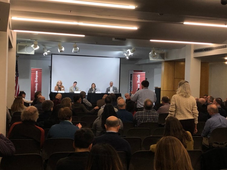 Members of the audience line up to ask questions of panelists Chris Chop of MaineHealth, Kristina Egan of Greater Portland Council of Government and Greg Day, director of Waterstone Properties at a business forum on mitigating traffic congestion in Portland. At far left is moderator Carol Coultas of the Press Herald.