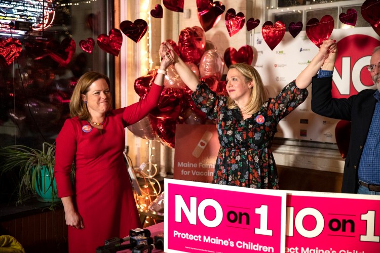 Caitlin Gilmet, center, and Dr.  Laura Blaisdell, co-chairs of the "No on 1" campaign, celebrate after addressing the crowd at their election night watch party at Salvage BBQ on Tuesday in Portland.