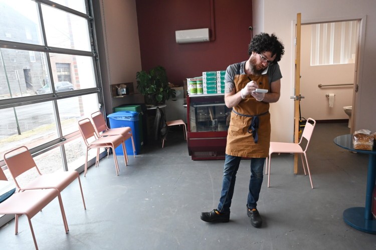 The Cheese Shop co-owner Will Sissle takes a pickup order over the phone.