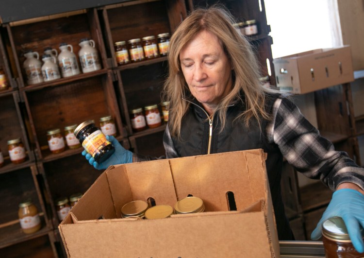 Linda DeFrancesco stocks shelves with her farm's own salsa, spreads, veggies and salsa at DeFrancesco Farm Stand in Northford, Conn., on Thursday.
