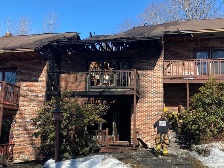 Firefighters work on the apartment building at 85 Smithfield Road in Oakland after it caught fire on Sunday morning. 