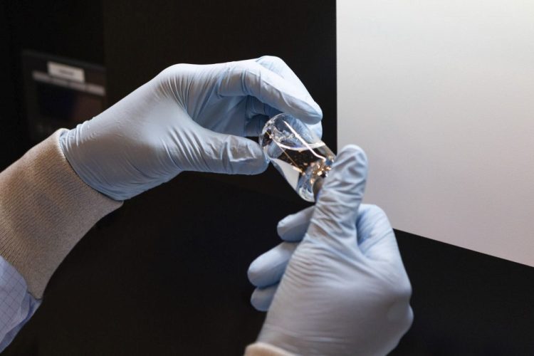 A vial of the investigational drug remdesivir is visually inspected at a Gilead manufacturing site in the United States. Given through an IV, the medication is designed to interfere with an enzyme that reproduces viral genetic material. 